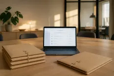 Bärbar dator och prydligt staplade dokumentmappar på ett konferensbord