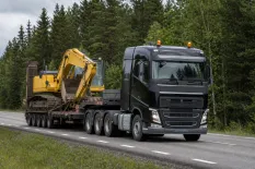 Grävmaskin säkrad på en maskintrailer inför transport på väg