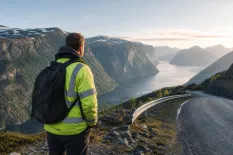 Anläggningsarbetare vid en norsk arbetsplats med fjäll i bakgrunden