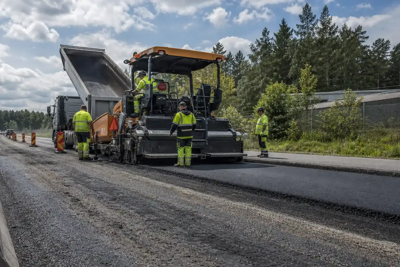 Vägarbete med avstängning, arbetsfordon och varningsskyltar